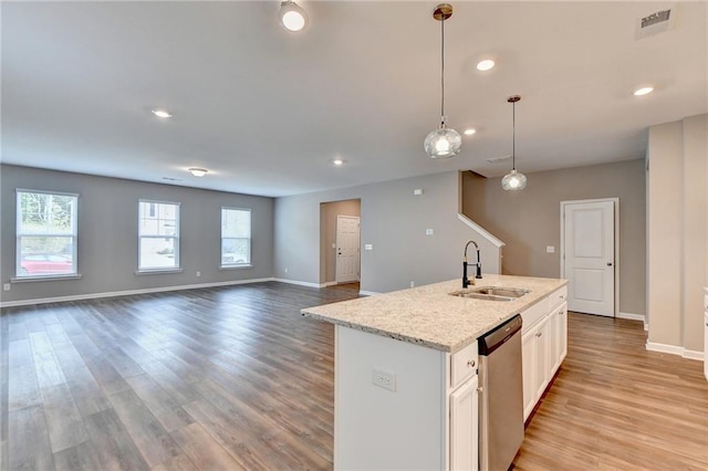 kitchen with stainless steel dishwasher, white cabinets, sink, pendant lighting, and light hardwood / wood-style flooring