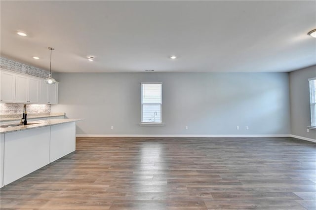 unfurnished living room with sink and dark hardwood / wood-style flooring