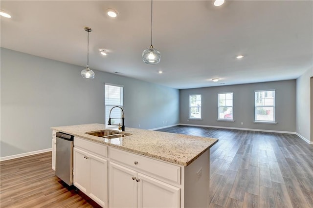 kitchen featuring hanging light fixtures, sink, white cabinetry, dishwasher, and hardwood / wood-style floors