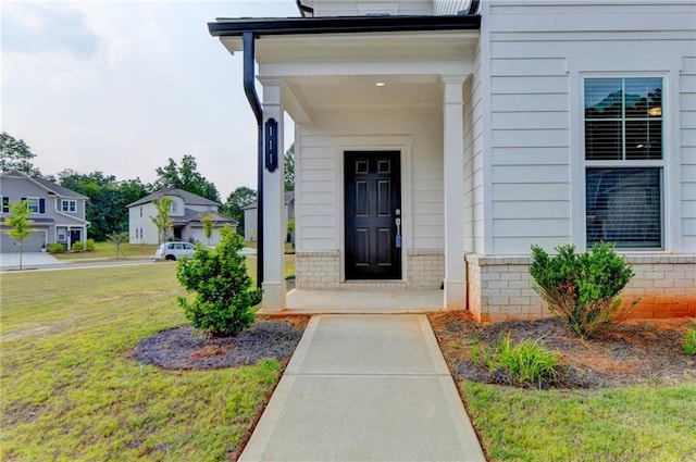 view of exterior entry featuring a lawn