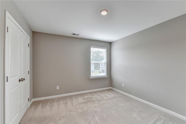 spare room featuring light colored carpet