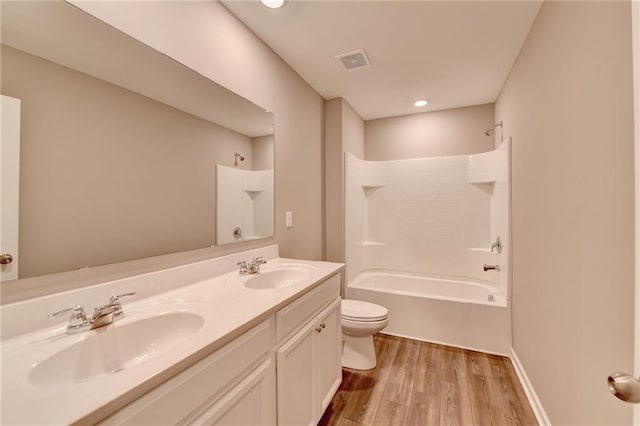 full bathroom featuring  shower combination, vanity, hardwood / wood-style floors, and toilet