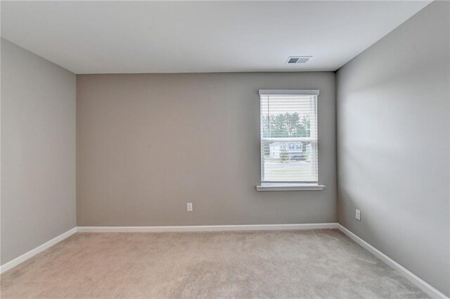 spare room featuring light carpet