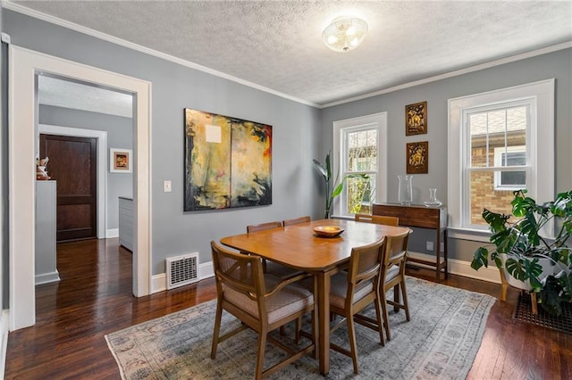 dining space featuring crown molding, dark wood-type flooring, and a textured ceiling