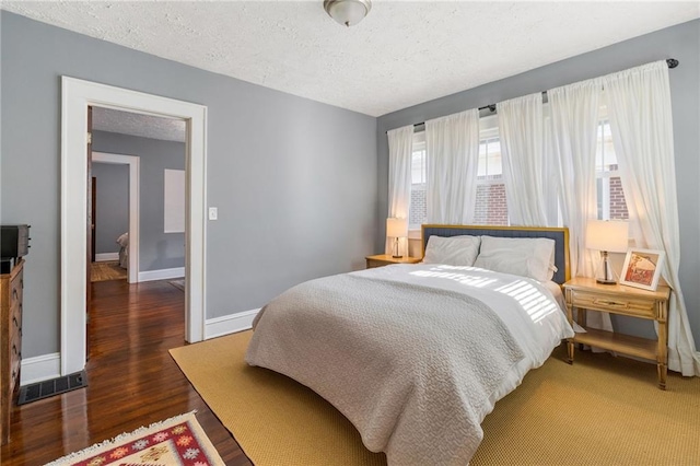 bedroom with dark hardwood / wood-style flooring and a textured ceiling