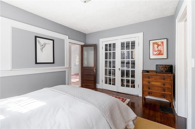 bedroom with wood-type flooring, a textured ceiling, and french doors