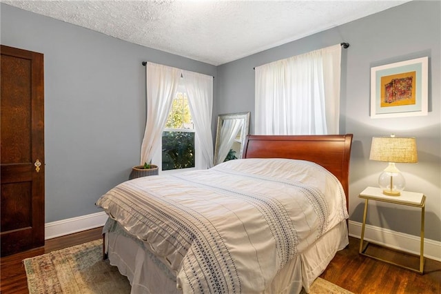 bedroom featuring a textured ceiling and dark wood-type flooring