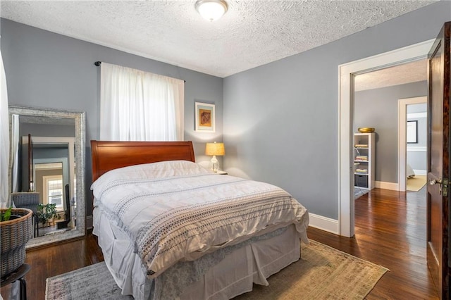 bedroom featuring a textured ceiling, dark hardwood / wood-style floors, and multiple windows