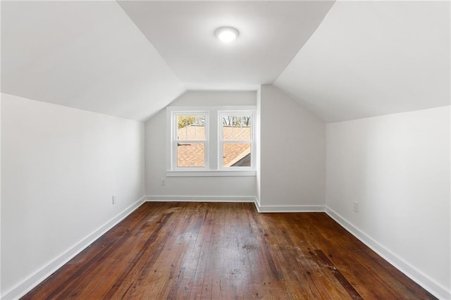 additional living space with vaulted ceiling and dark hardwood / wood-style floors