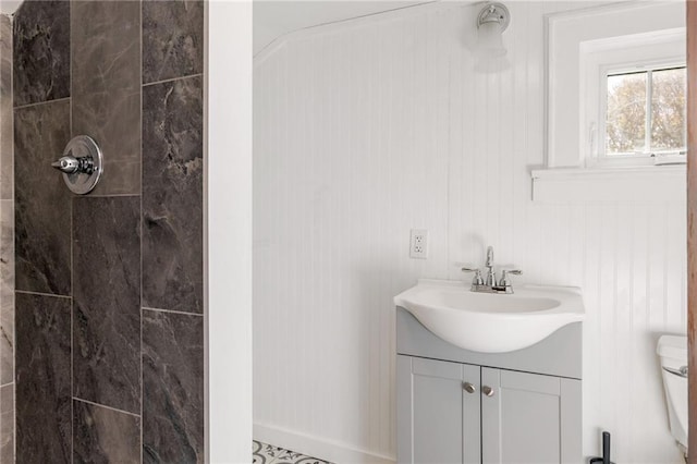 bathroom featuring vanity, toilet, and a tile shower