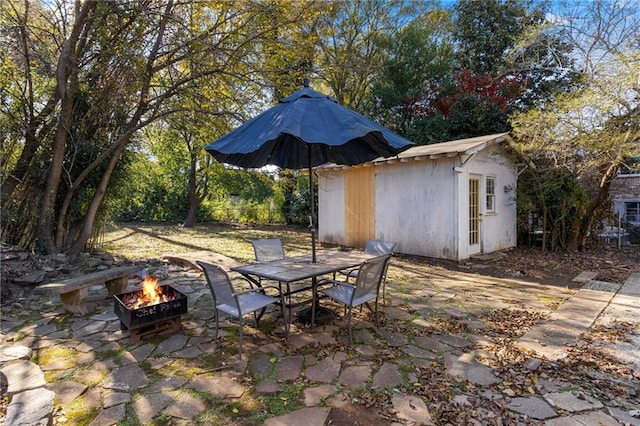 view of patio / terrace with a shed and an outdoor fire pit