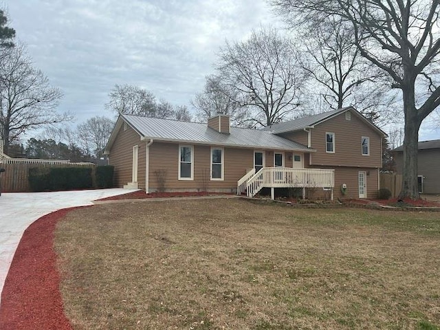 back of house featuring a deck and a lawn