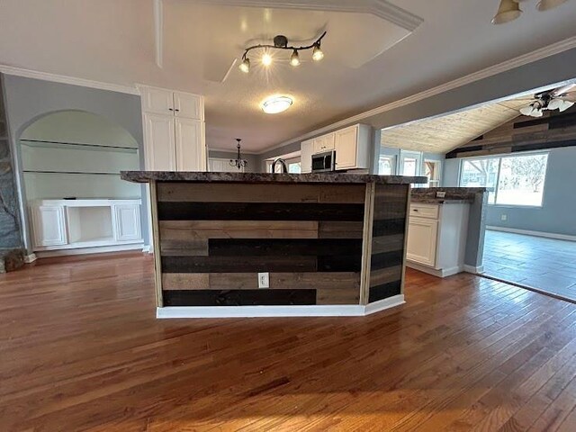 kitchen with sink, crown molding, vaulted ceiling, dark hardwood / wood-style flooring, and white cabinetry