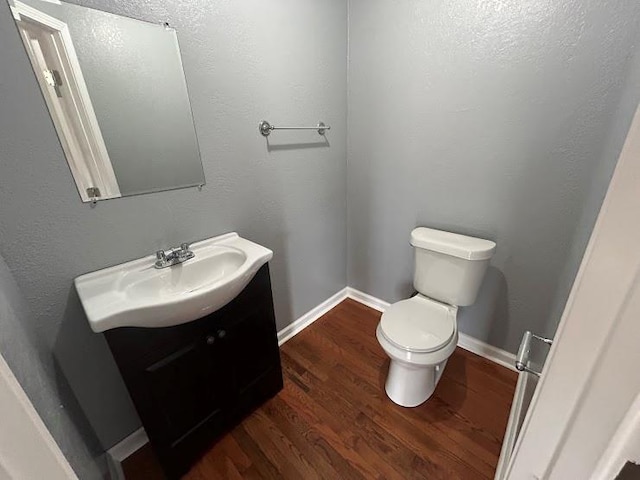 bathroom with vanity, hardwood / wood-style flooring, and toilet