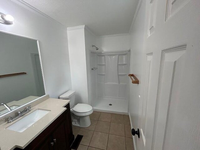 bathroom featuring vanity, a shower, crown molding, tile patterned flooring, and toilet