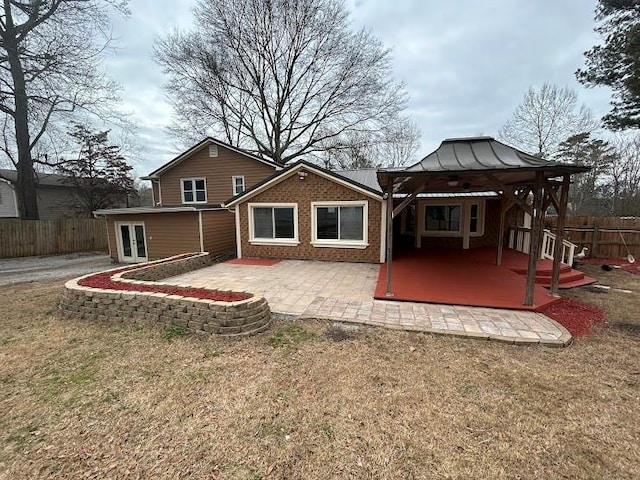 rear view of property featuring a gazebo, a patio, and a yard