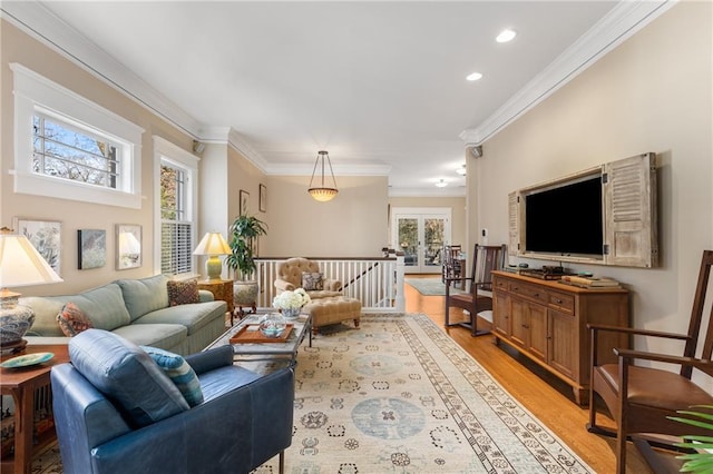 living room with crown molding and light hardwood / wood-style flooring