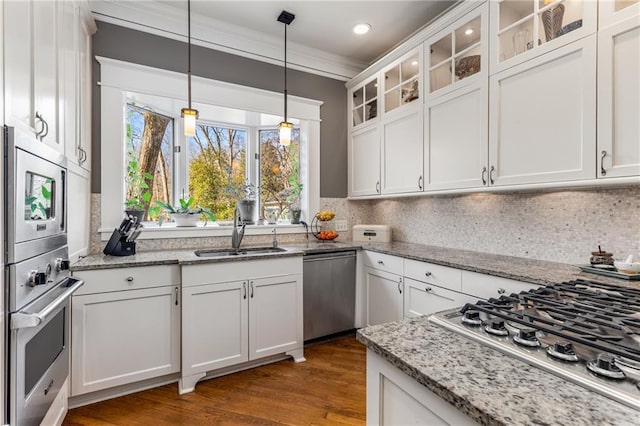 kitchen featuring white cabinetry, appliances with stainless steel finishes, sink, and light stone counters