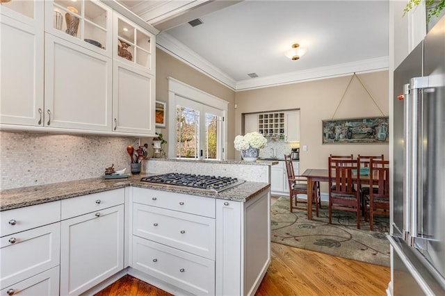 kitchen with white cabinetry, light stone countertops, crown molding, and stainless steel appliances