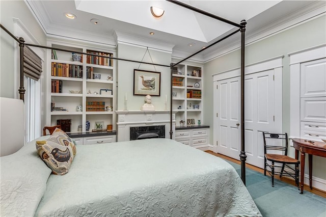 bedroom featuring ornamental molding, a fireplace, a skylight, and wood-type flooring