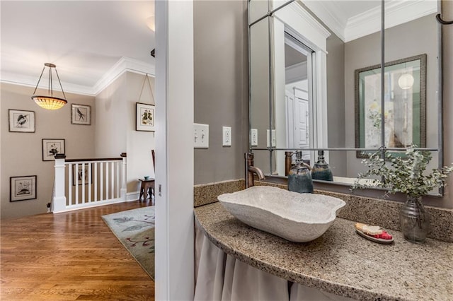 bathroom with sink, crown molding, and hardwood / wood-style flooring