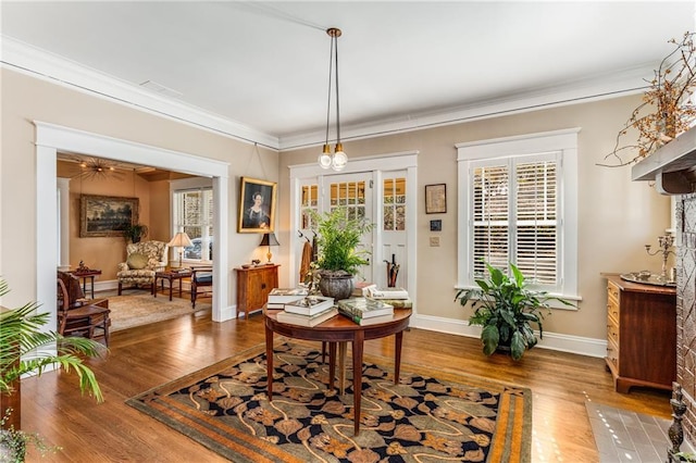 sitting room with hardwood / wood-style floors, ornamental molding, and a wealth of natural light