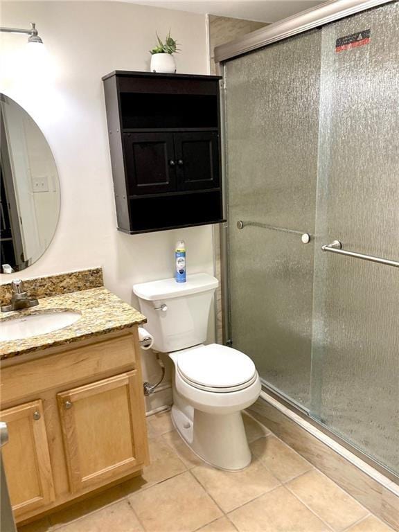 full bathroom with toilet, a shower stall, vanity, and tile patterned flooring