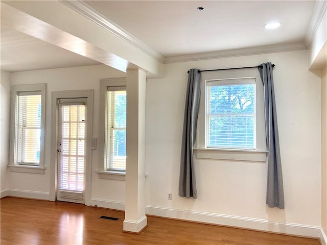 entryway featuring visible vents, baseboards, wood finished floors, and crown molding