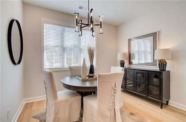 dining room featuring a notable chandelier, visible vents, baseboards, and light wood-style floors