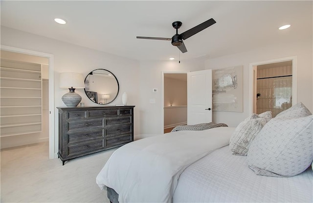 bedroom featuring a ceiling fan, recessed lighting, a closet, light carpet, and a walk in closet