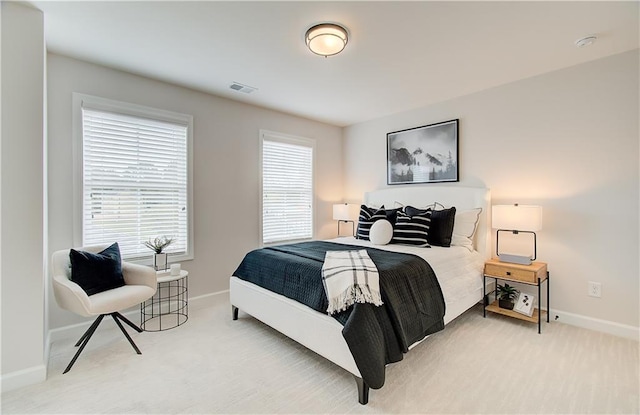 bedroom featuring visible vents, baseboards, and light colored carpet