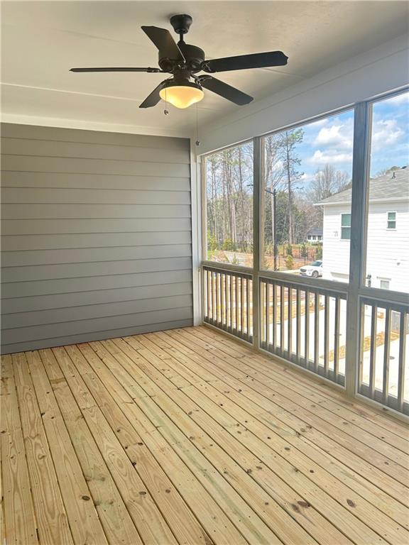 unfurnished sunroom with ceiling fan