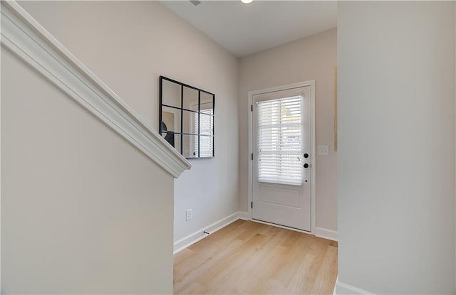 foyer with light wood-style flooring and baseboards