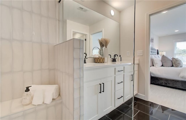 ensuite bathroom featuring a sink, visible vents, ensuite bath, and tile patterned flooring