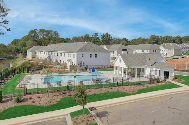 exterior space featuring a residential view, a community pool, and fence