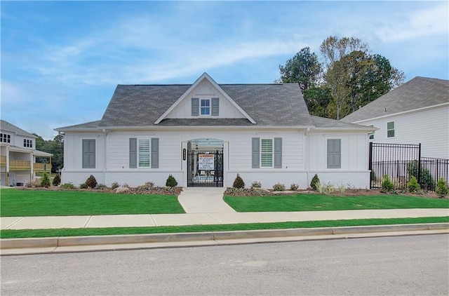 view of front of home with brick siding, a front lawn, and fence