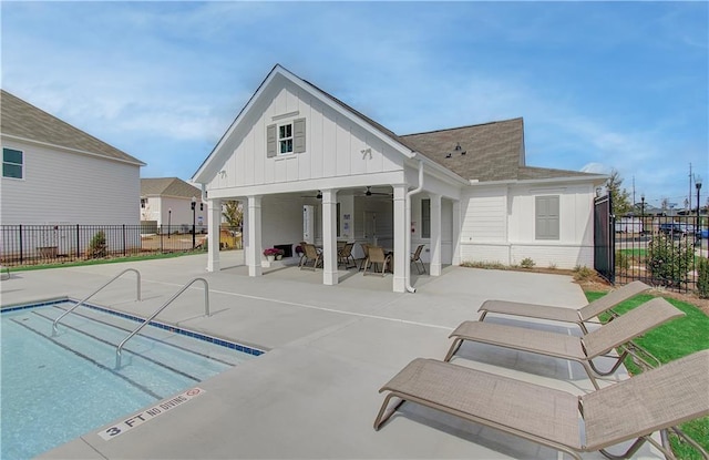 rear view of house featuring a patio area, board and batten siding, a ceiling fan, and fence