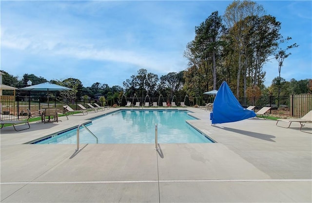 community pool with a patio and fence