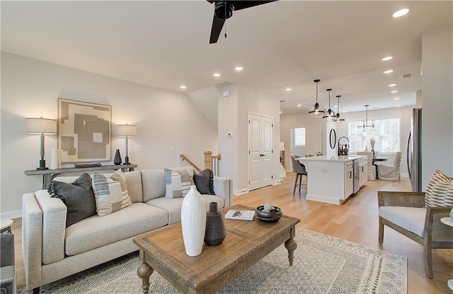 living area featuring a ceiling fan, visible vents, baseboards, recessed lighting, and light wood-type flooring