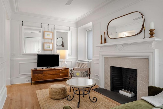 75 Ponce De Leon Ave NE Unit 1006, Atlanta, GA 30308 - living room featuring wood finished floors, a fireplace, a decorative wall, and ornamental molding