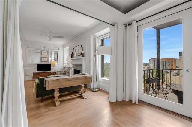 75 Ponce De Leon Ave NE Unit 1006, Atlanta, GA 30308 - living area featuring crown molding, wood finished floors, a fireplace, a ceiling fan, and a decorative wall