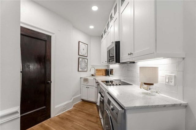75 Ponce De Leon Ave NE Unit 1006, Atlanta, GA 30308 - kitchen featuring stainless steel microwave, white cabinets, black electric cooktop, tasteful backsplash, and recessed lighting