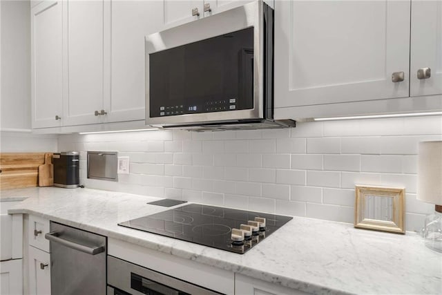 75 Ponce De Leon Ave NE Unit 1006, Atlanta, GA 30308 - kitchen with appliances with stainless steel finishes, white cabinets, and decorative backsplash