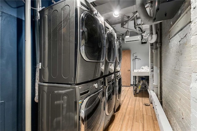 75 Ponce De Leon Ave NE Unit 1006, Atlanta, GA 30308 - washroom with stacked washer / drying machine, wood finished floors, and a wall mounted AC