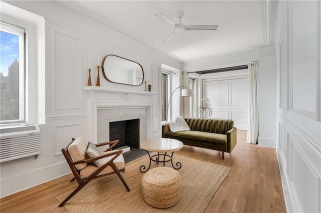 75 Ponce De Leon Ave NE Unit 1006, Atlanta, GA 30308 - living area featuring a ceiling fan, crown molding, light wood finished floors, a decorative wall, and a fireplace