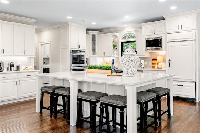 kitchen with stainless steel appliances, white cabinetry, tasteful backsplash, crown molding, and recessed lighting
