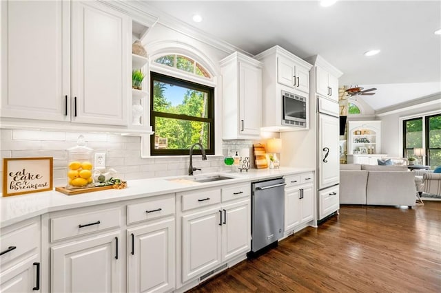 kitchen featuring stainless steel appliances, a sink, a ceiling fan, open floor plan, and white cabinets