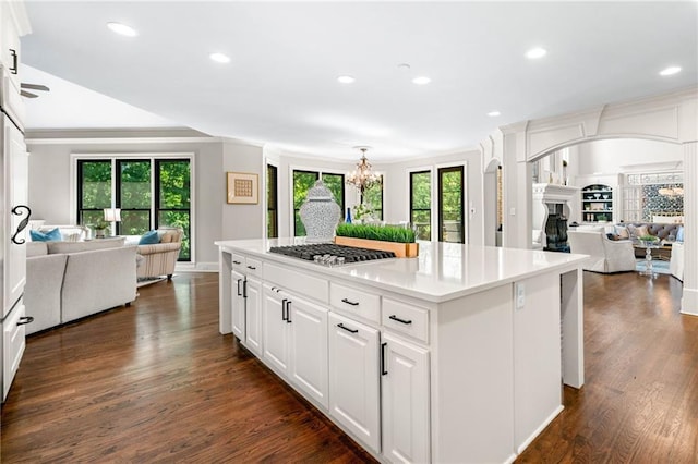 kitchen with open floor plan, stainless steel gas stovetop, plenty of natural light, recessed lighting, and crown molding