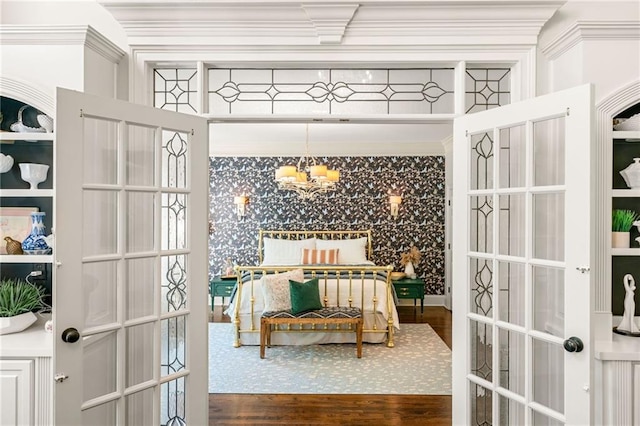 bedroom featuring wood finished floors, a chandelier, ornamental molding, and french doors
