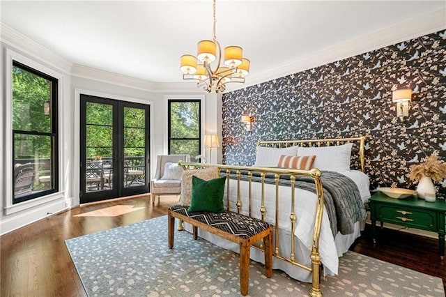 bedroom with a chandelier, ornamental molding, wood finished floors, and wallpapered walls